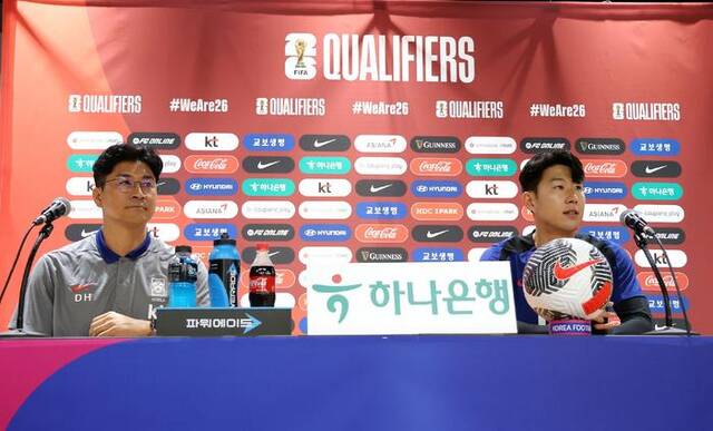韩国队临时主帅金度勋（左）携队长孙兴慜（右）出席赛前新闻发布会。