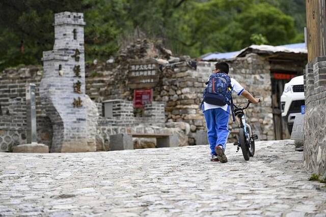 小朋友经过石峡村内的古堡遗址（5月31日摄）。新华社记者陈钟昊摄