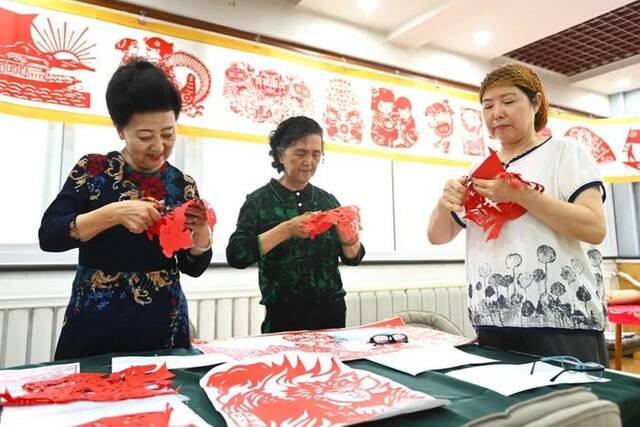 近日，宁夏银川市金凤区长城花园社区居民在创作剪纸作品。新华社记者毛竹摄