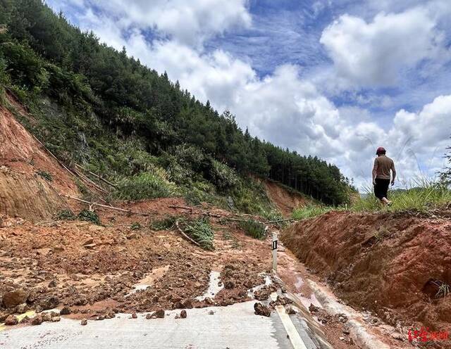 ▲20日，龙岩市通往太拔镇的国道被封，回乡的村民爬坡查看，发现100米内有三处塌方