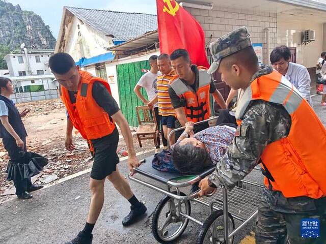 6月20日，武警广西总队桂林支队官兵在桂林市南溪山医院用推车转运病人。新华社发（黄卓森摄）