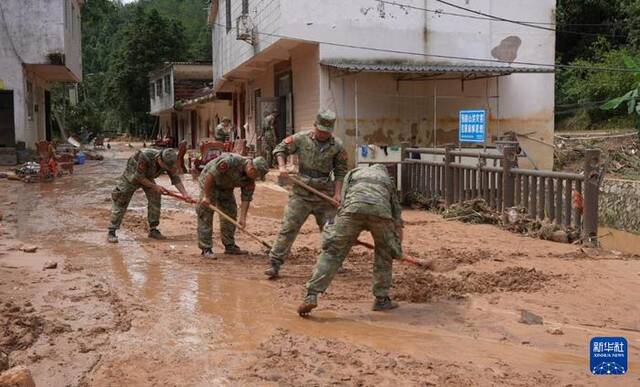6月19日，广东省梅州市平远县人武部组织民兵清理灾区道路淤泥。新华社发（曾瑜摄）