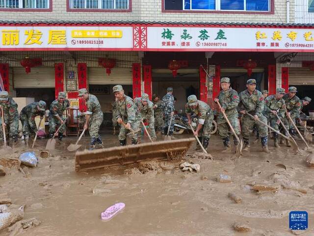 6月20日，福建省军区龙岩军分区民兵在龙岩市上杭县蓝溪镇进行清扫淤泥工作。新华社发（江晓珍摄）