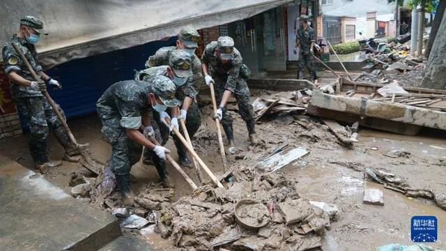 6月21日，武警广西总队桂林支队官兵在桂林市七星区东江路清除淤泥及杂物。新华社记者刘一诺摄