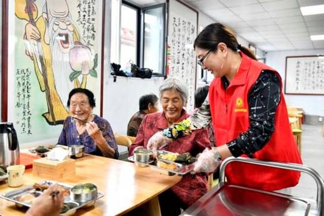 山东省乳山市城区街道腾甲庄村幸福食堂，志愿者为老人们配送午餐。新华社记者郭绪雷摄