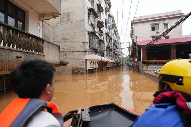 2024年7月2日，湖南岳阳，平江县遭遇洪水侵袭，救援人员划着皮艇寻找转移被困群众。视觉中国图