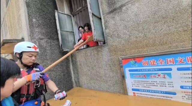 湖南省红十字蓝天救援队的队员给被困居民送物资。受访者供图