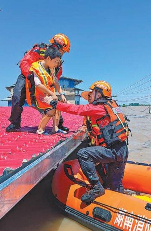 7月6日，湖南省湘潭市消防救援支队舟艇编队再次进入华容县团东村进行搜救工作，成功转移被困群众。许琦摄（人民视觉）