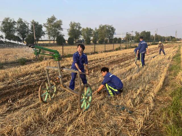 风电河南区域公司员工协助河南省尉氏县多个村庄村民对农田里的农作物进行浇灌