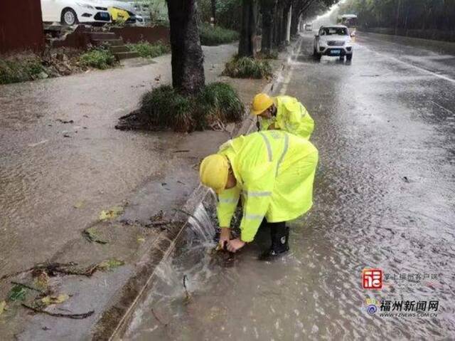 工作人员于东三环路清掏边井树叶垃圾保障过水率