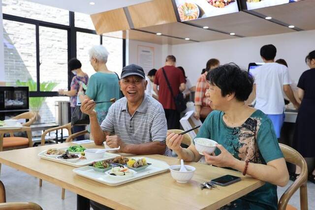 两位老人正在杭州翠苑一区老年食堂吃饭。（杭州翠苑一区社区供图）