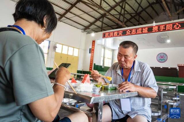 7月30日，转移安置的群众在湘潭县河口中学安置点吃午餐。新华社记者陈思汗摄