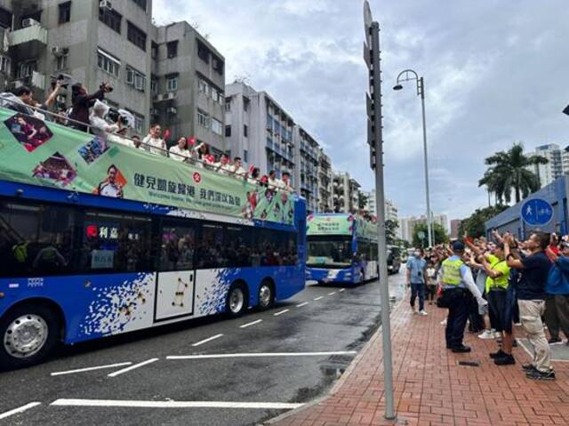 中国香港代表团奥运健儿坐敞篷巴士巡游。图自香港星岛网