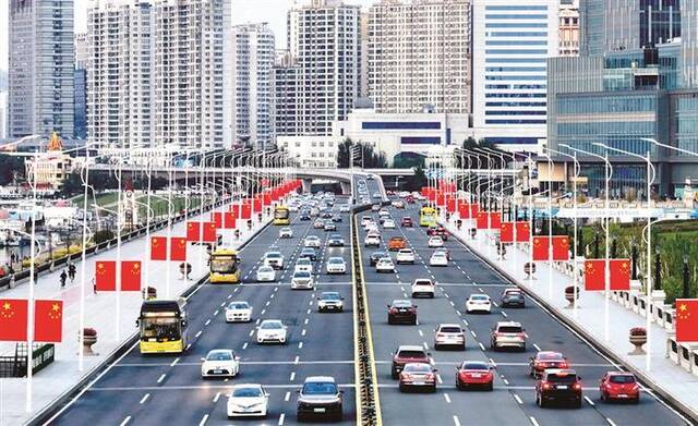 近日，黑龙江省哈尔滨市友谊西路等道路街头，整齐悬挂着成排的五星红旗。图片来源：视觉中国