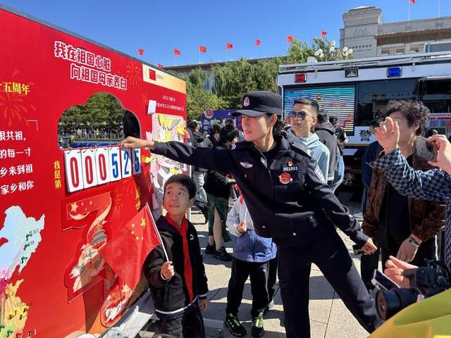 “为民服务车”执勤民警为游客介绍“向祖国母亲表白”展板。新京报记者彭镜陶摄