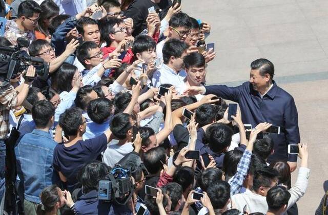 △2018年5月2日，习近平总书记在北京大学考察时同道路两旁师生亲切握手。